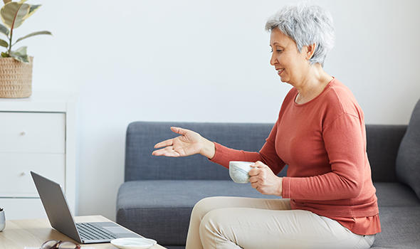 Freepik_senior-woman-sitting-on-sofa-drinking-coffee-and-has-online-conference-on-laptop-computer-at-home_annastills.jpg