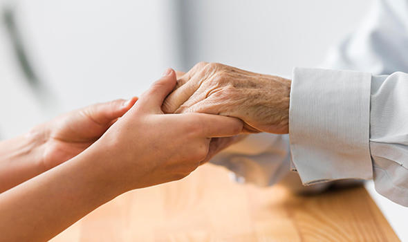 Pflegeversicherung_Freepik_nurse-holding-senior-man-s-hands-for-comfort_freepik_590x350.jpg