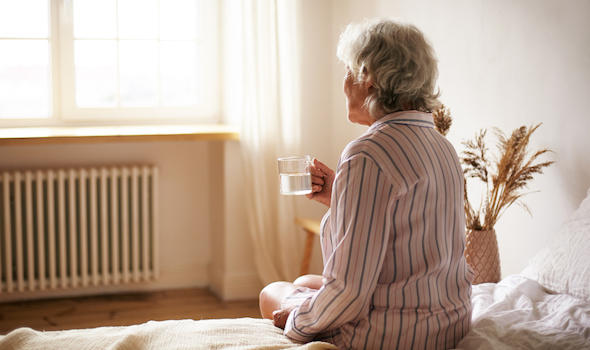 rear-view-of-senior-sixty-year-old-woman-with-gray-hair-holding-mug-washing-down-sleeping-pill-suffering-from-insomnia-elderly-retired-female-taking-medicine-with-water-sitting-in-bedroom.jpeg