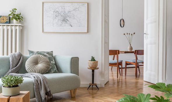 cozy-and-creative-composition-of-stylish-living-room-interior-design-with-green-sofa-wooden-furniture-plants-and-accessories-white-walls-parquet-floor.jpeg