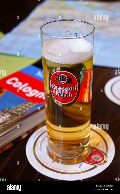 ein-bedrucktes-glas-reissdorf-kolsch-bier-an-einer-bar-in-koln-koln-nordrhein-westfalen-deutschland-mit-einem-englischen-baedeker-reisefuhrer-cygk6r.jpg